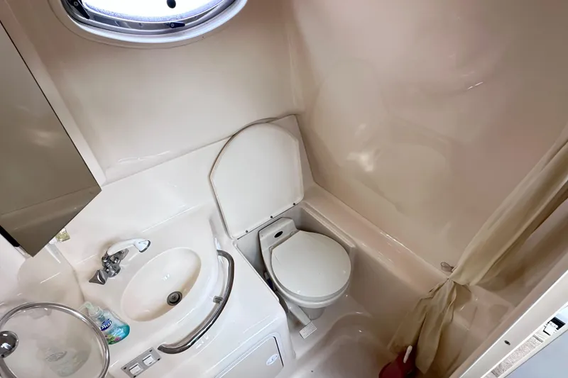 Slide: The Image of Bathroom interior of 2000 Sea Ray 290 Sundancer boat, featuring sink and toilet. - 16