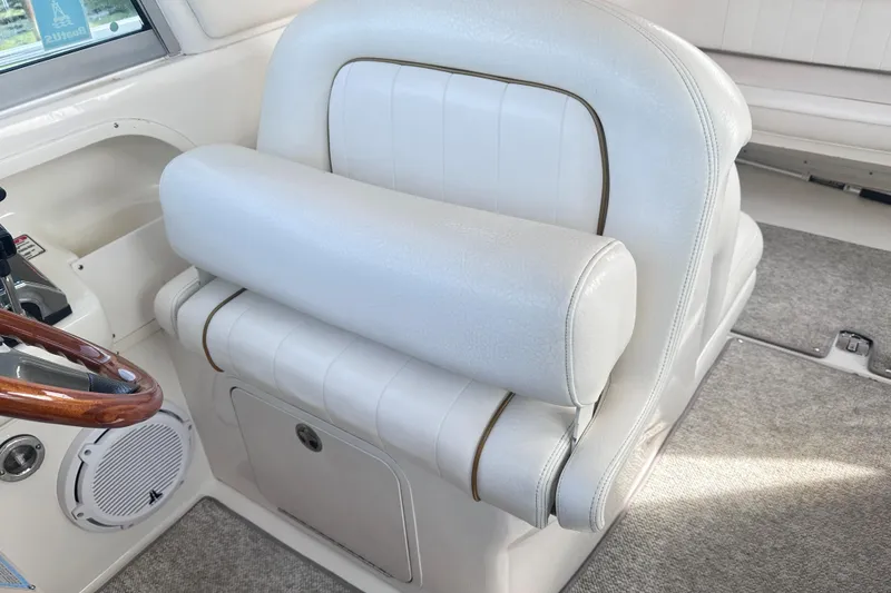Slide: The Image of Captain's seat on 2000 Sea Ray 290 Sundancer, featuring white upholstery and wood-accented steering wheel. - 6
