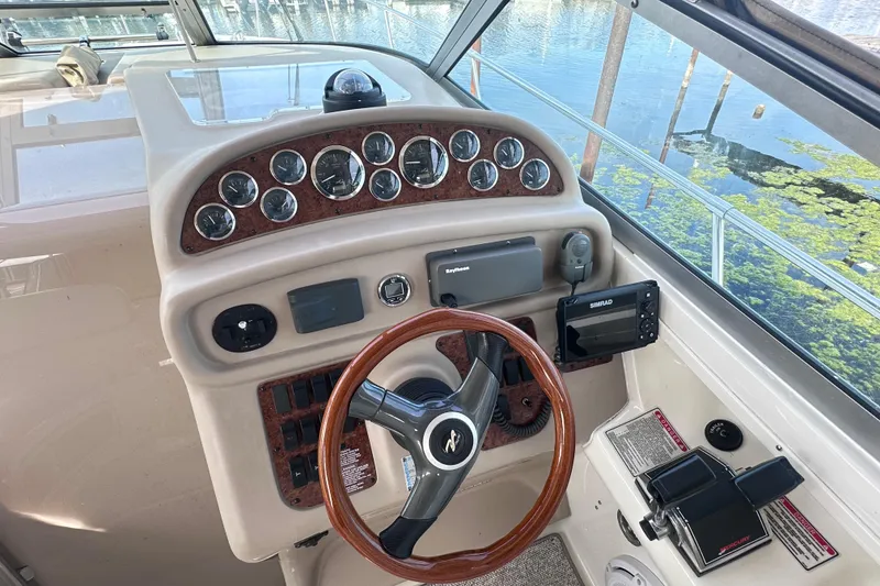Slide: The Image of Helm of 2000 Sea Ray 290 Sundancer with gauges, steering wheel, and navigation equipment. - 7
