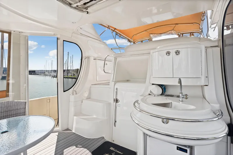 Slide: The Image of 2005 Carver 466 Motor Yacht interior with sink, seating, and marina view. - 10