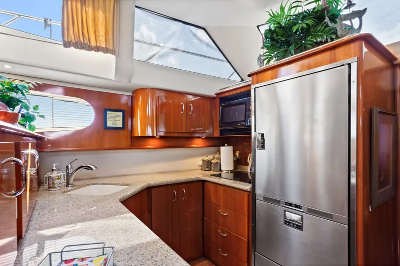 Slide: The Image of Luxurious kitchen interior of 2005 Carver 466 Motor Yacht with modern appliances and wood cabinetry. - 17