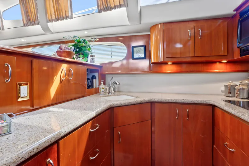 Slide: The Image of Luxurious kitchen interior of 2005 Carver 466 Motor Yacht with wood cabinetry and granite countertops. - 18