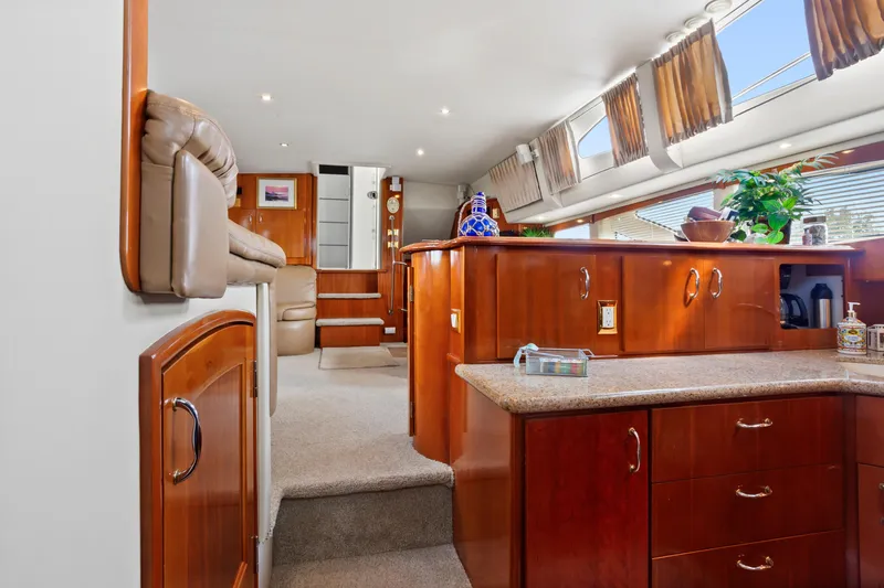 Slide: The Image of Luxurious interior of 2005 Carver 466 Motor Yacht with elegant wood cabinetry and plush seating. - 19