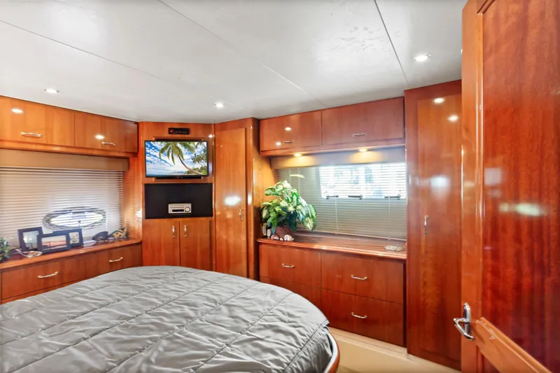 Slide: The Image of Luxurious 2005 Carver 466 Motor Yacht bedroom with wood cabinetry and modern amenities. - 21