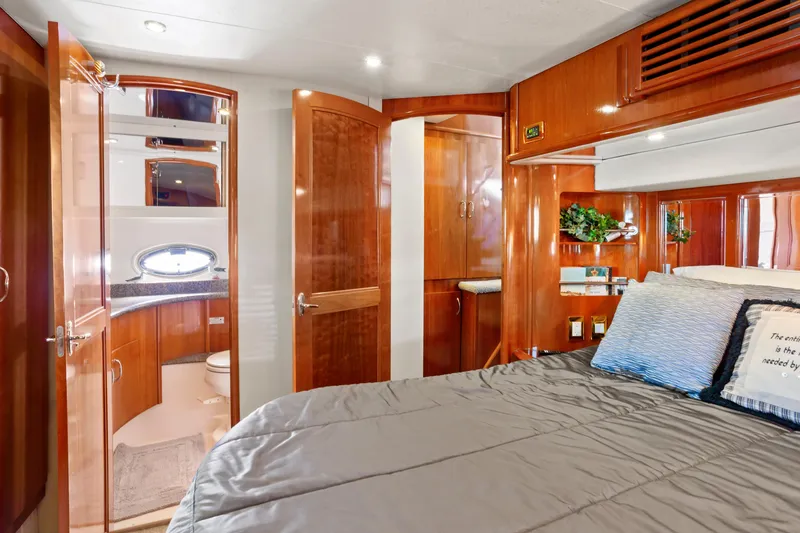 Slide: The Image of Luxurious 2005 Carver 466 Motor Yacht bedroom with ensuite bathroom and elegant wood finishes. - 22