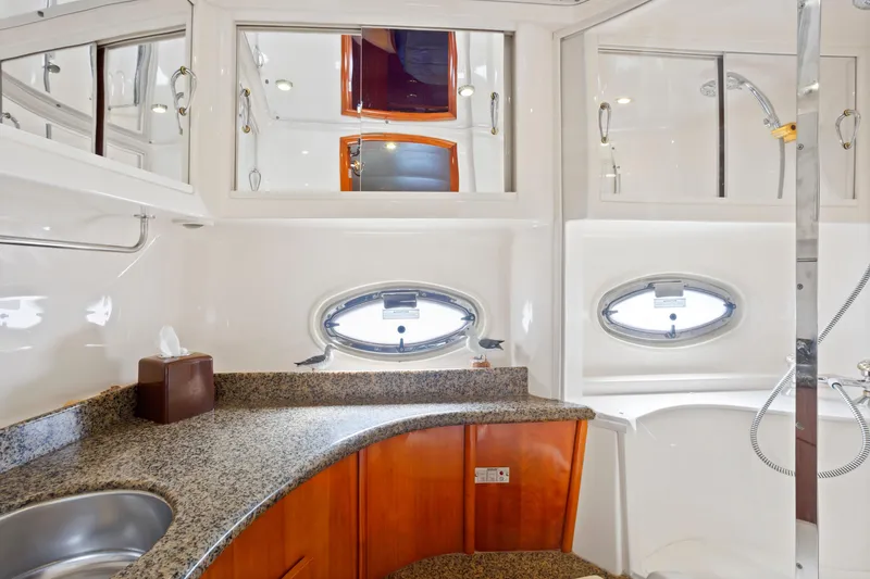 Slide: The Image of Luxurious bathroom in 2005 Carver 466 Motor Yacht with granite countertops and oval windows. - 23