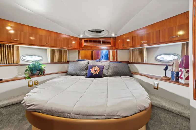 Slide: The Image of Luxurious 2005 Carver 466 Motor Yacht bedroom with elegant wood cabinetry and cozy bedding. - 25