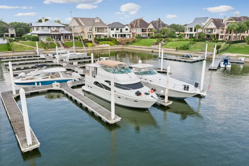 Slide: The Image of 2005 Carver 466 Motor Yacht docked at a marina with waterfront homes in the background. - 3