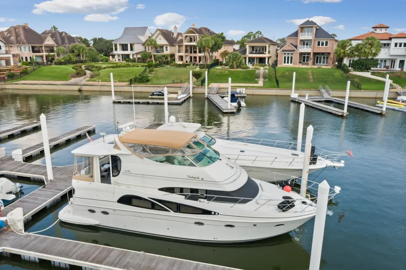 Slide: The Image of 2005 Carver 466 Motor Yacht docked in a scenic marina with waterfront homes. - 5