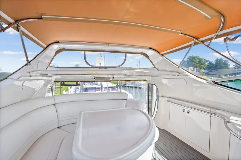 Slide: The Image of 2005 Carver 466 Motor Yacht interior with white seating and orange canopy. - 8