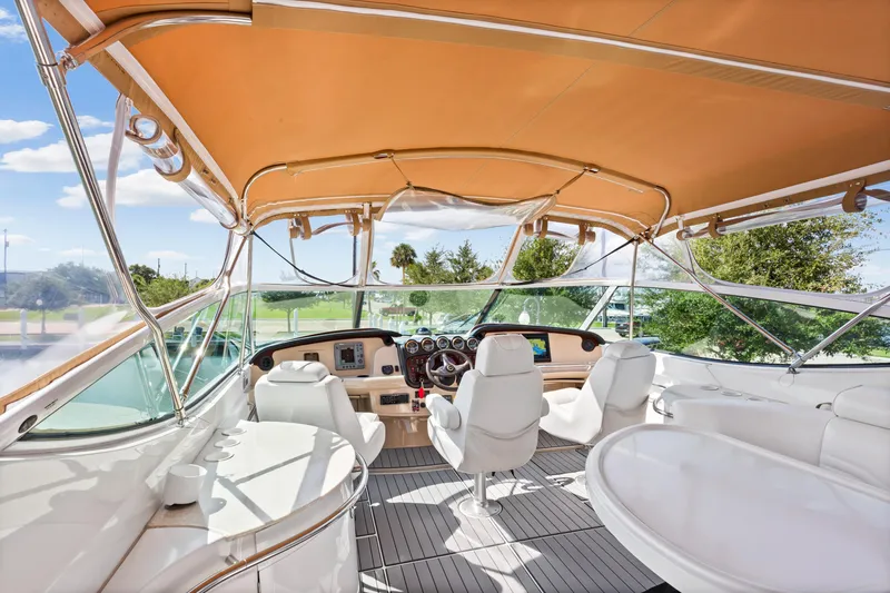 Slide: The Image of 2005 Carver 466 Motor Yacht helm with white seating and orange canopy. - 9