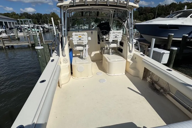 Slide: The Image of 2011 Parker 2510 XL Walkaround boat with spacious deck and dual seating at marina. - 8