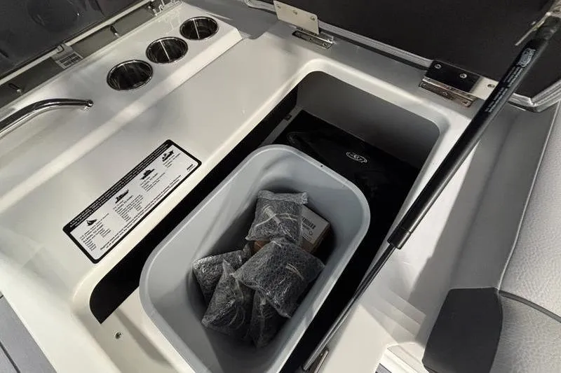 Slide: The Image of Interior storage compartment of 2026 Cobalt R33 boat with cup holders and storage bin. - 24