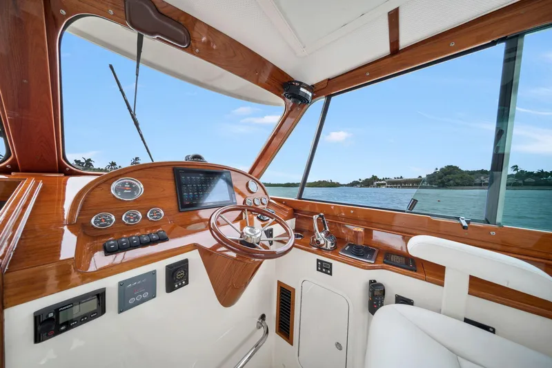 Slide: The Image of Helm of 2019 Hinckley Picnic Boat 34 with wooden dashboard and scenic water view. - 6