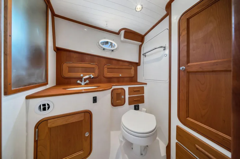 Slide: The Image of 2019 Hinckley Picnic Boat 34 bathroom with wood accents and modern fixtures. - 8