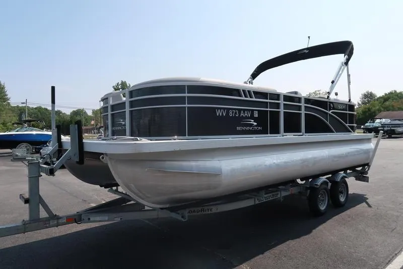 Slide: The Image of 2023 Bennington 22 SXSR pontoon boat on trailer in parking lot. - 2