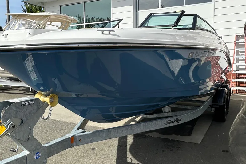 Slide: The Image of 2023 Sea Ray SPX 230 Outboard boat on trailer, blue hull, parked outdoors. - 3