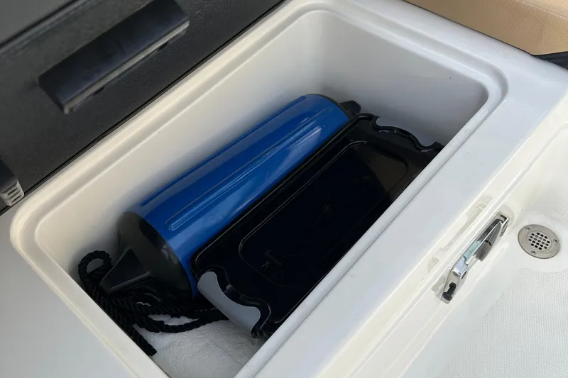 Slide: The Image of Storage compartment in 2023 Sea Ray SPX 230 Outboard with blue fender and black tray. - 9