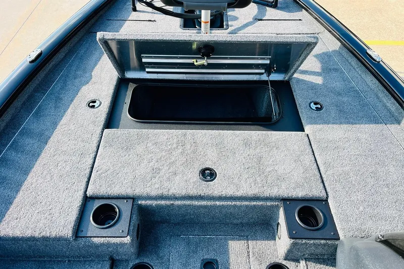 Slide: The Image of 2026 Tracker Pro Team 195 boat interior with open storage compartment and carpeted deck. - 16