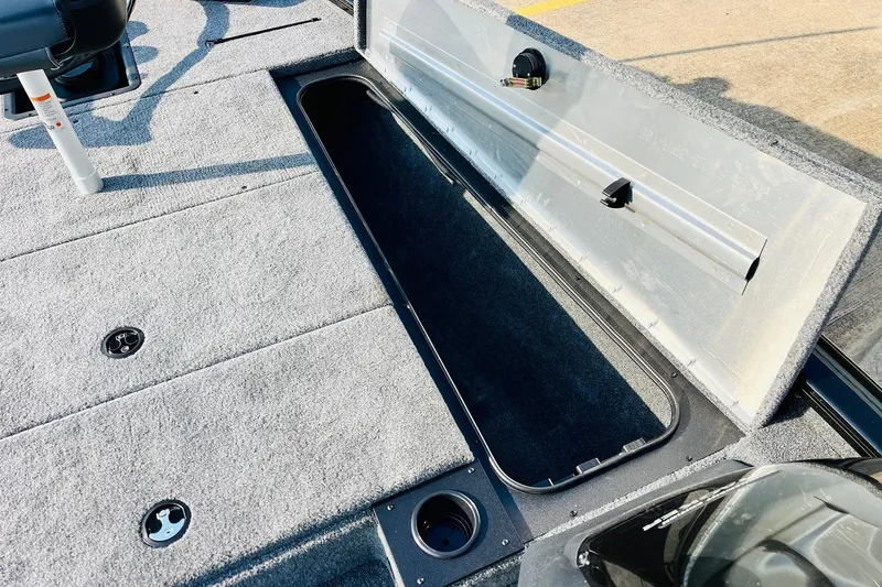 Slide: The Image of 2026 Tracker Pro Team 195 boat with open storage compartment on carpeted deck. - 19