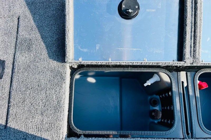 Slide: The Image of Open storage compartment on 2026 Tracker Pro Team 195 boat, featuring carpeted interior. - 37