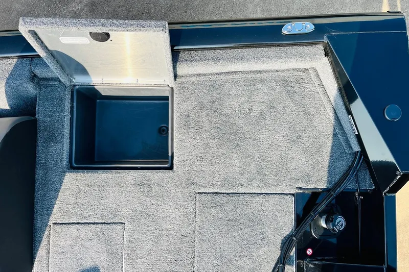 Slide: The Image of 2026 Tracker Pro Team 195 boat interior with open storage compartment and carpeted flooring. - 44