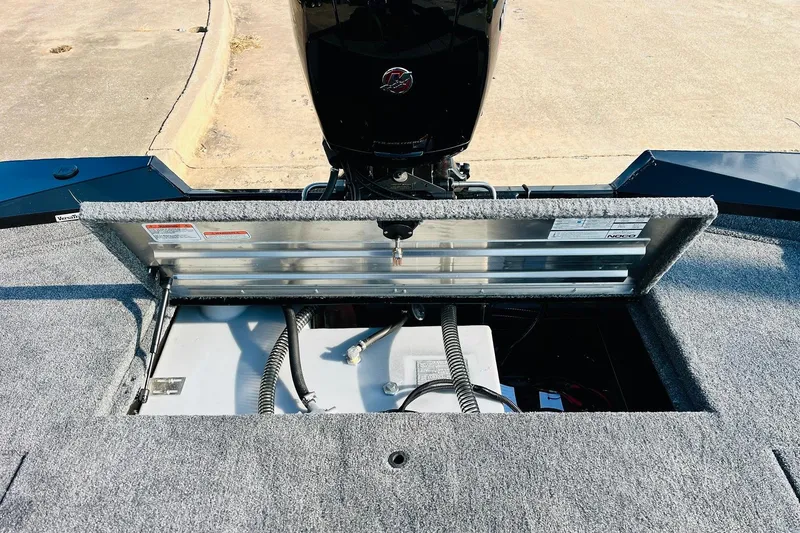 Slide: The Image of 2026 Tracker Pro Team 195 boat battery compartment with open hatch, showing wiring and components. - 45