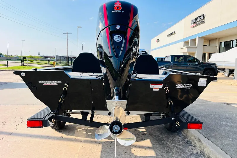 Slide: The Image of 2026 Tracker Pro Team 195 boat with powerful outboard motor, parked outside dealership. - 6
