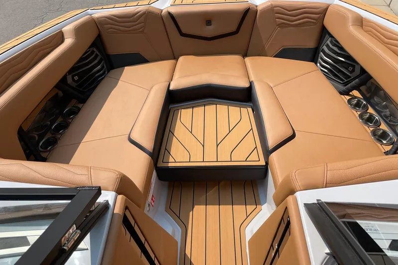 Slide: The Image of 2026 Nautique Super Air Nautique G23 boat interior with tan seating and cup holders. - 11