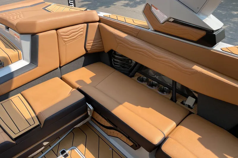 Slide: The Image of 2026 Nautique Super Air Nautique G23 interior with tan leather seating and cup holders. - 9