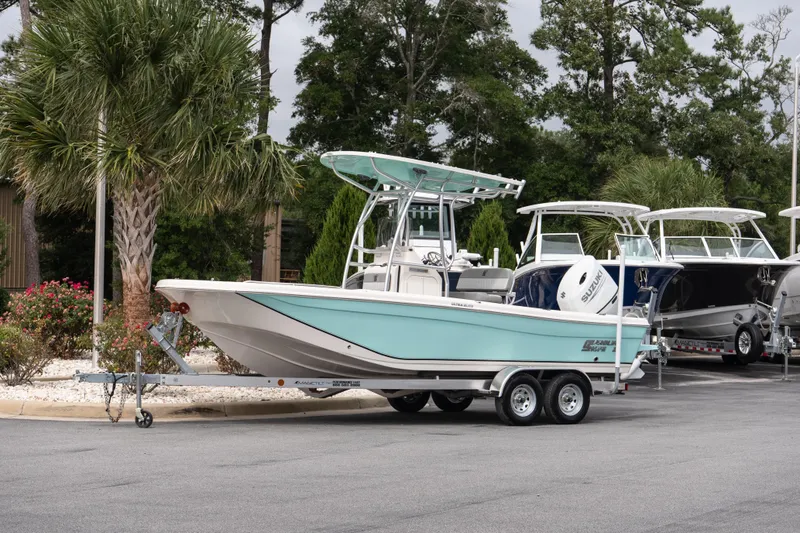 The Image of 2026 Carolina Skiff 21 Ultra Elite boat on trailer, parked near palm trees. - 1