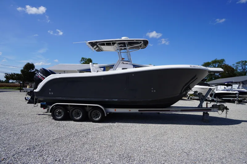 The Image of 2016 Pro-Line 29 Grand Sport boat on a trailer under a clear blue sky. - 0