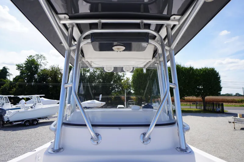 Slide: The Image of 2016 Pro-Line 29 Grand Sport boat with T-top and clear windshield, parked outdoors. - 21