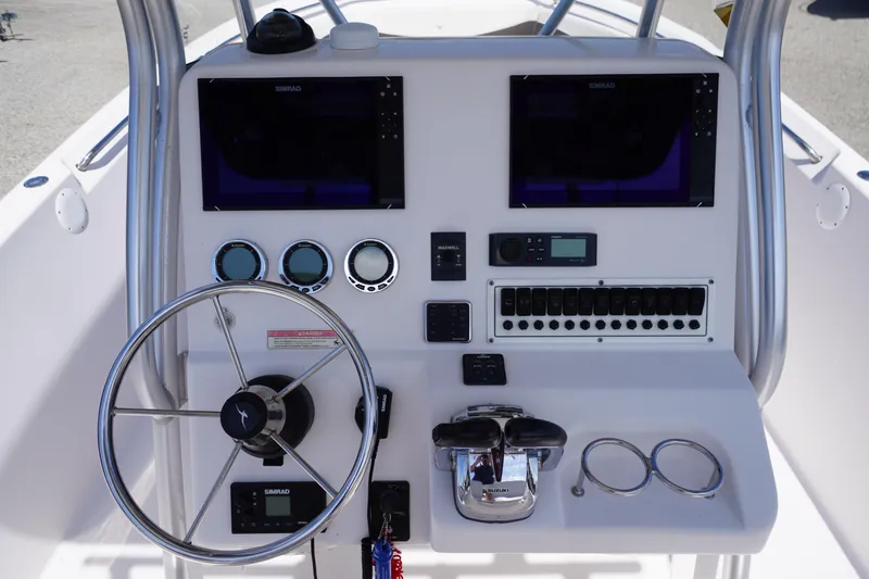 Slide: The Image of Control panel of 2016 Pro-Line 29 Grand Sport boat with steering wheel and navigation displays. - 28