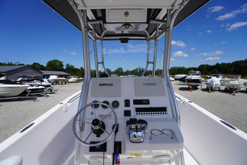Slide: The Image of 2016 Pro-Line 29 Grand Sport boat dashboard with steering wheel and controls, parked in a marina. - 31