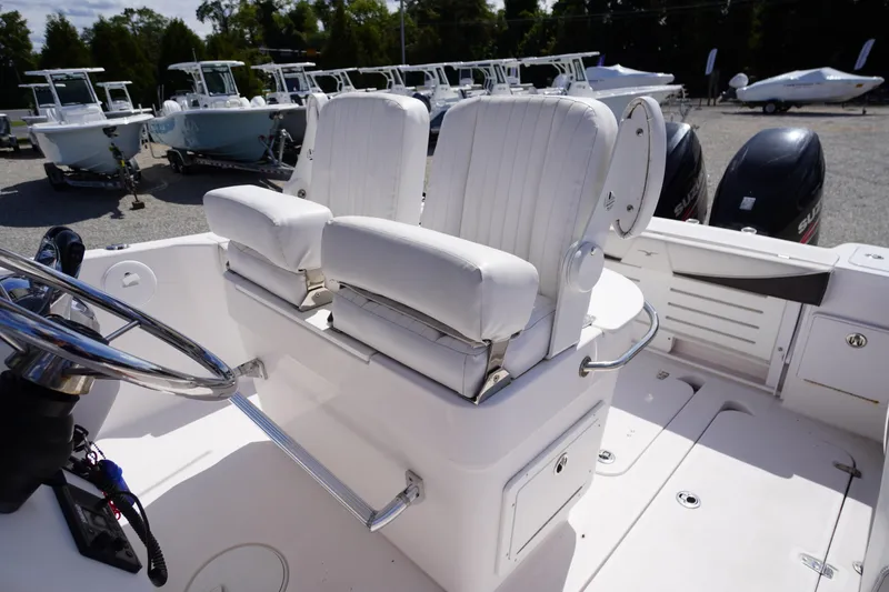 Slide: The Image of 2016 Pro-Line 29 Grand Sport boat interior with dual white captain's chairs and steering wheel. - 35