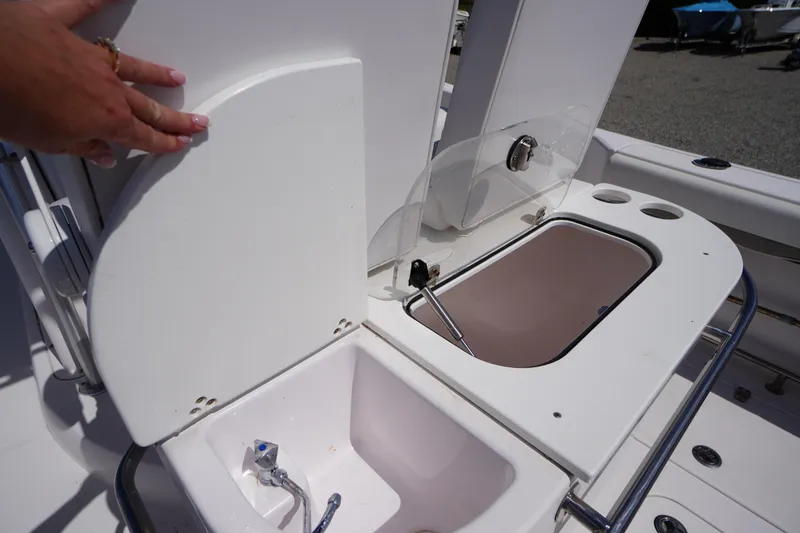 Slide: The Image of 2016 Pro-Line 29 Grand Sport boat sink and storage area with hand opening compartment. - 39