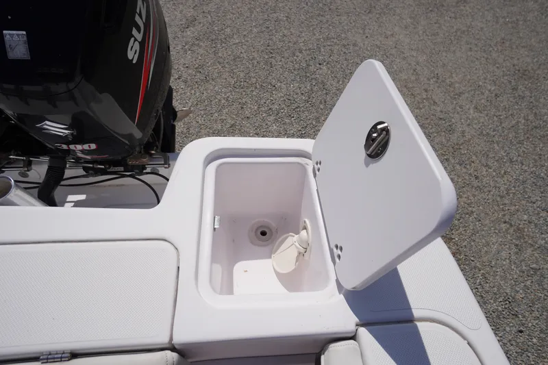 Slide: The Image of 2016 Pro-Line 29 Grand Sport boat with open storage compartment and Suzuki outboard motor. - 51
