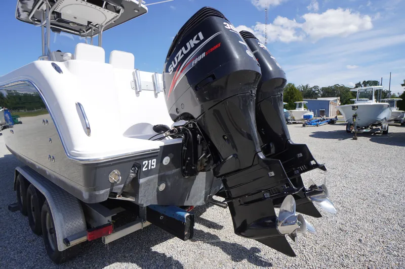 Slide: The Image of 2016 Pro-Line 29 Grand Sport boat with dual Suzuki outboard motors on a trailer. - 58