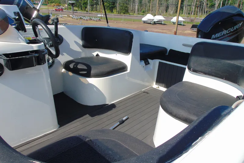 Slide: The Image of 2016 Bayliner 160 Element boat interior with black seating and Mercury engine. - 7
