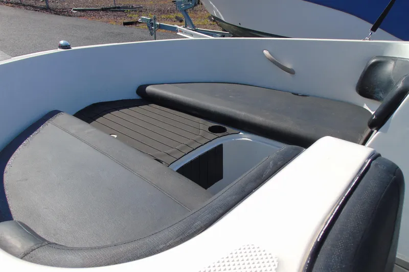 Slide: The Image of 2016 Bayliner 160 Element boat interior seating area with black cushions. - 8