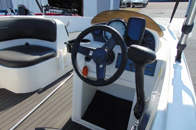 Slide: The Image of 2016 Bayliner 160 Element boat interior with steering wheel and control panel. - 9