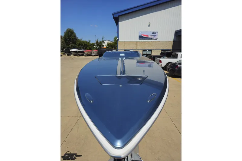Slide: The Image of 2007 Donzi 35 ZR boat with sleek blue hull, parked outdoors near a building. - 20