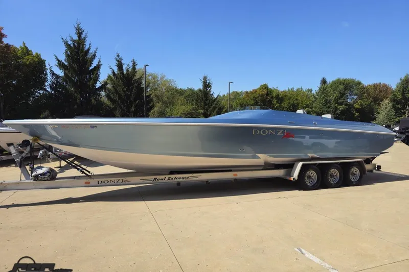 Slide: The Image of 2007 Donzi 35 ZR speedboat on trailer, parked outdoors under clear blue sky. - 23