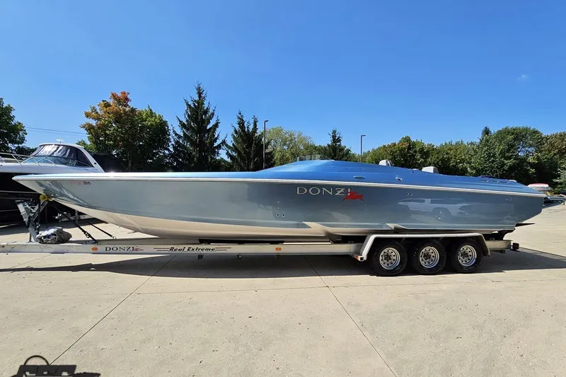 Slide: The Image of 2007 Donzi 35 ZR speedboat on trailer, parked outdoors under clear blue sky. - 24