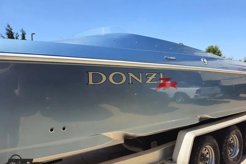 Slide: The Image of 2007 Donzi 35 ZR speedboat on trailer, sleek design under clear blue sky. - 26