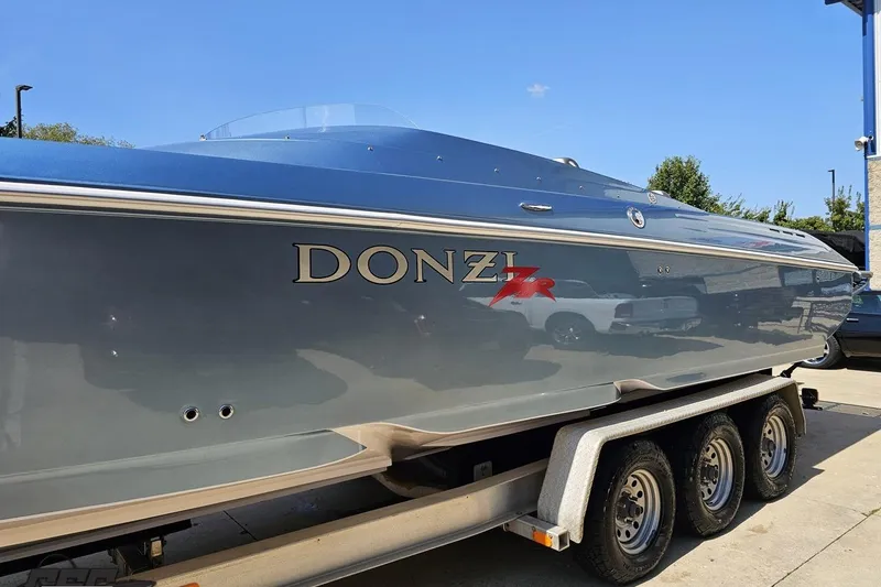 Slide: The Image of 2007 Donzi 35 ZR speedboat on trailer, sleek design, blue finish, sunny day. - 27