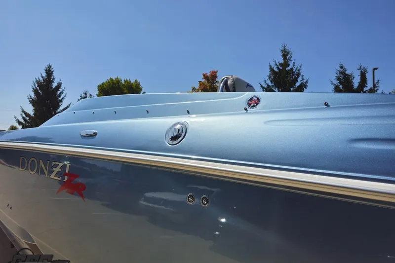 Slide: The Image of 2007 Donzi 35 ZR boat with sleek blue exterior under clear sky. - 32