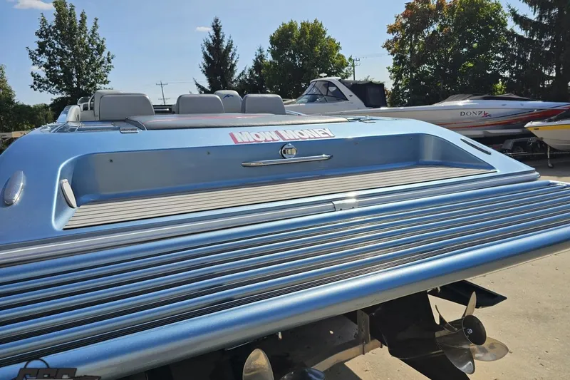 Slide: The Image of 2007 Donzi 35 ZR speedboat with "Now Money" decal, docked outdoors. - 37