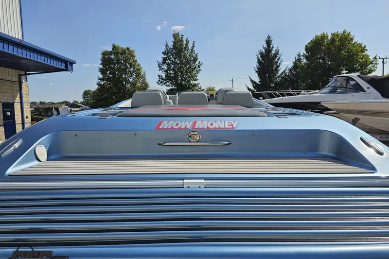 Slide: The Image of 2007 Donzi 35 ZR speedboat with "Mow Money" decal, docked under clear blue sky. - 43